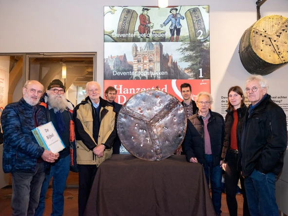 Het koperslagersgilde van 's-Hertogenbosch met in het midden conservator Anne van Geuns (l) en voormalig wethouder Thomas Walder (r) met de replica (Foto Viorica Cernica)