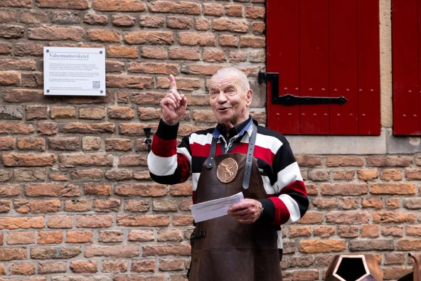 Voorman van het koperslagersgilde uit 's-Hertogenbosch Henny Hoppenbrouwers nam aanwezigen mee in het maakproces van de replica. (Foto Viorica Cernica)